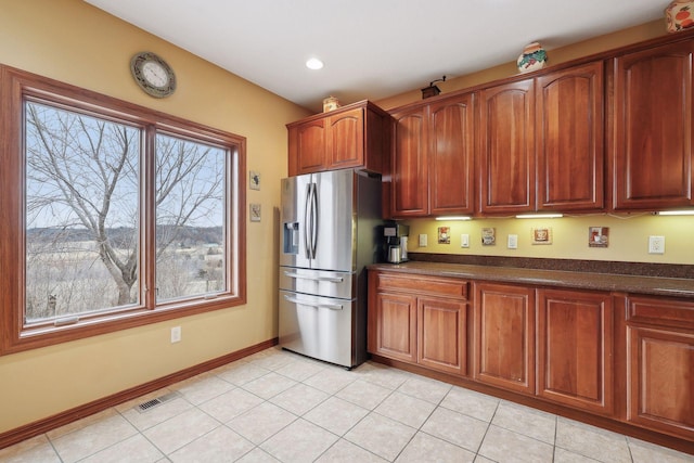 kitchen featuring light tile patterned flooring and stainless steel refrigerator with ice dispenser