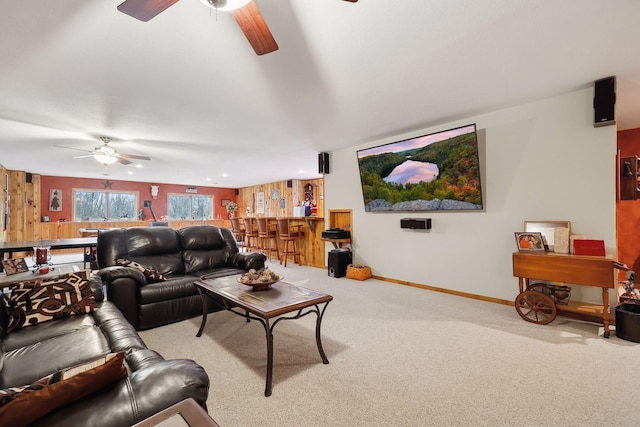 carpeted living room featuring wood walls and bar area