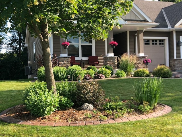 craftsman-style home with a garage, covered porch, and a front lawn