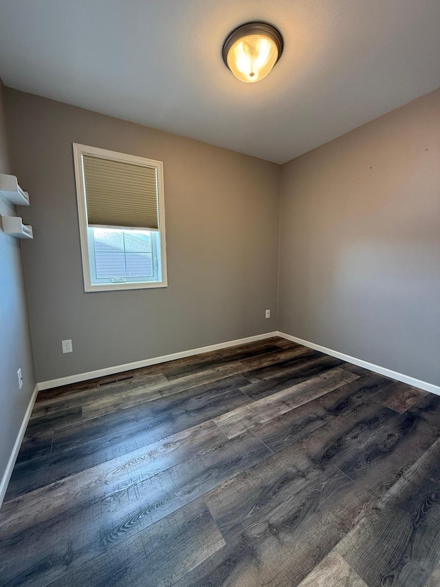 spare room featuring dark wood-type flooring