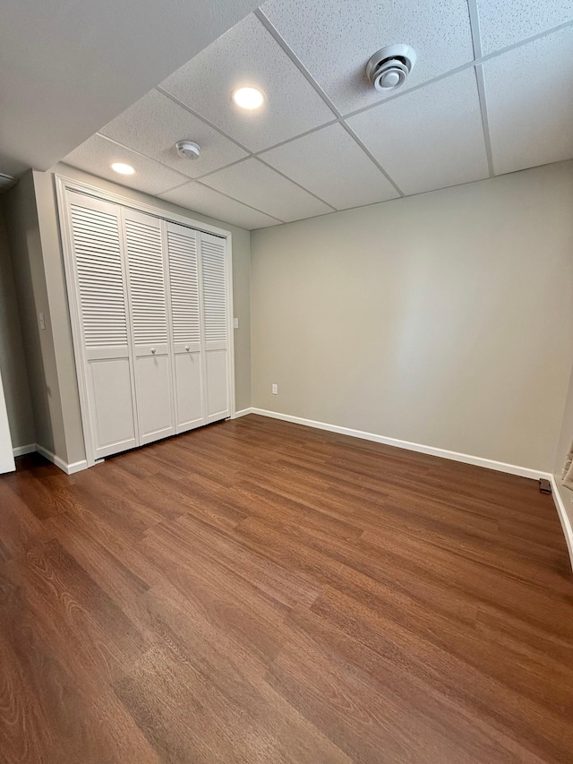 unfurnished bedroom featuring hardwood / wood-style floors, a closet, and a drop ceiling