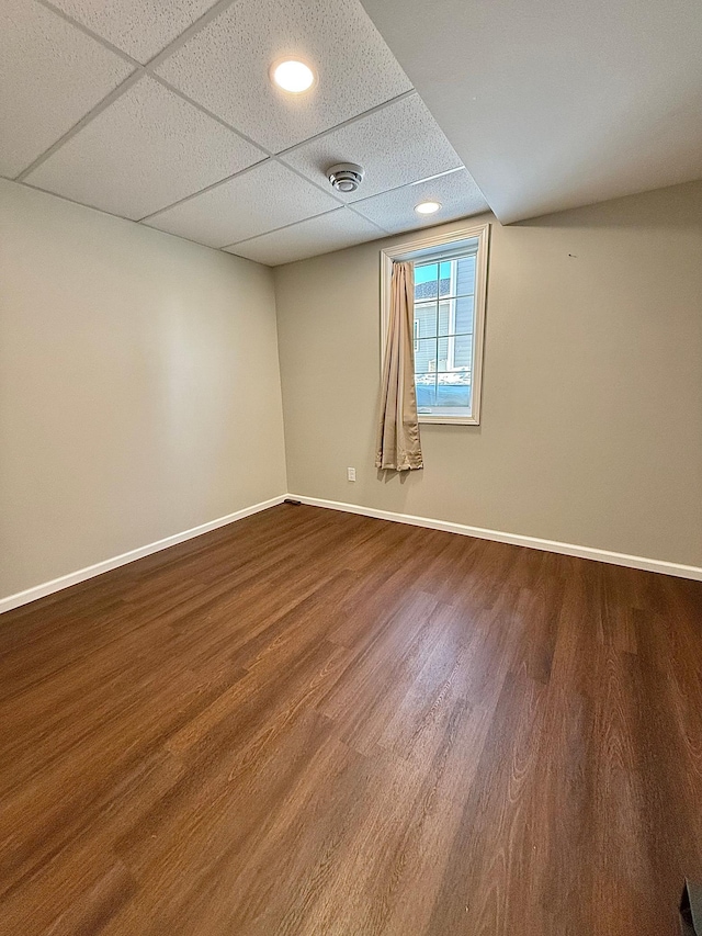 unfurnished room featuring wood-type flooring and a drop ceiling