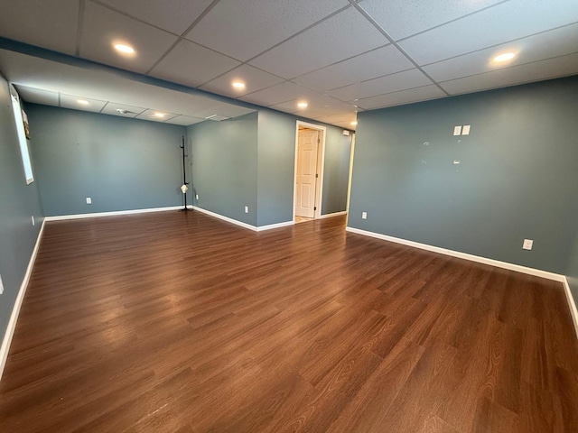 interior space with a paneled ceiling and hardwood / wood-style floors