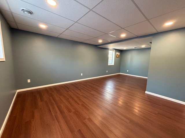 spare room with a drop ceiling and hardwood / wood-style floors