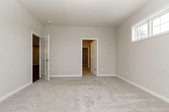 unfurnished bedroom with a spacious closet and light colored carpet