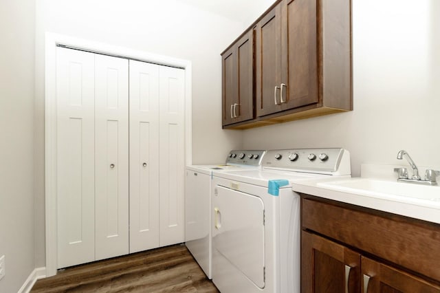 clothes washing area with cabinets, independent washer and dryer, sink, and dark wood-type flooring