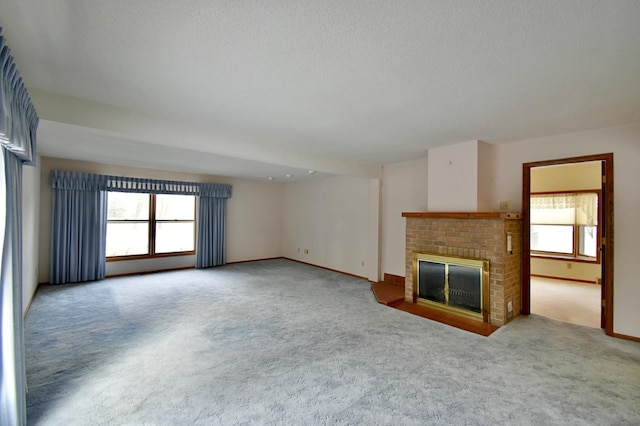 unfurnished living room with a textured ceiling, carpet floors, and a fireplace