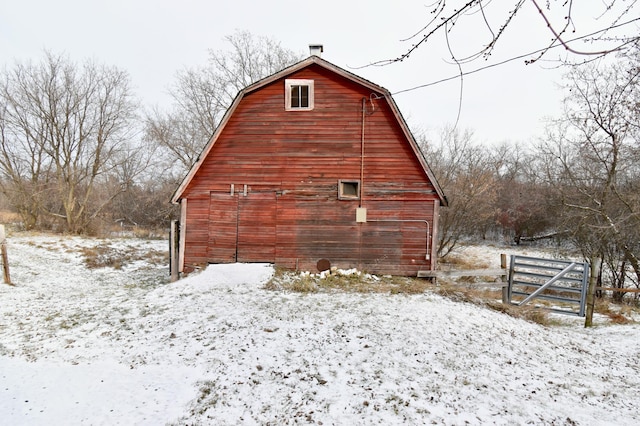 view of snowy exterior featuring an outbuilding