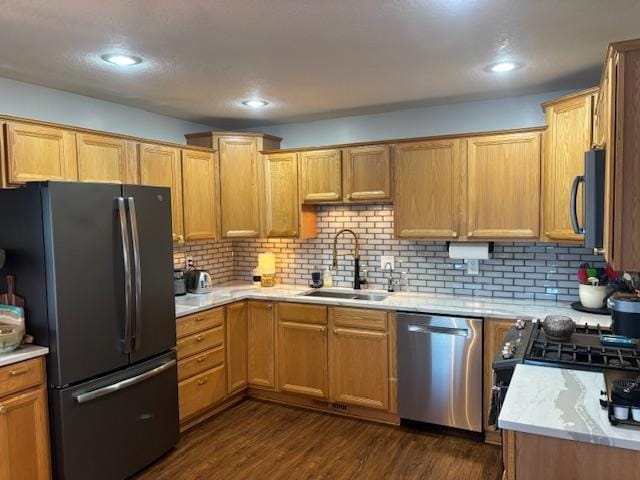 kitchen with stainless steel appliances, tasteful backsplash, dark wood-type flooring, and sink