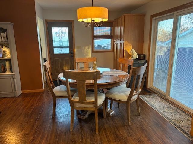 dining space featuring a notable chandelier, dark wood-type flooring, and a wealth of natural light