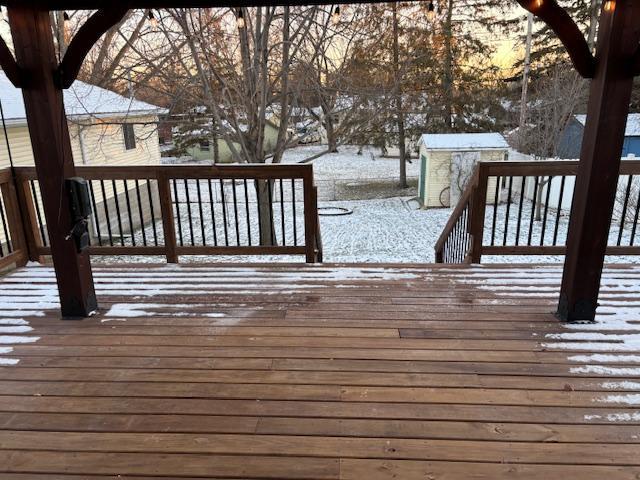 snow covered deck featuring a shed