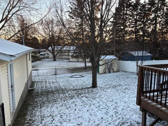 yard covered in snow featuring a storage shed