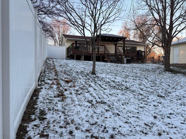 yard covered in snow with a deck