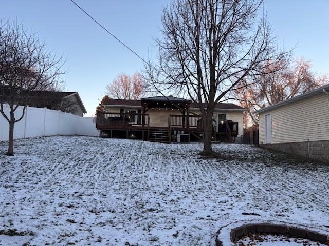 snow covered house featuring a deck