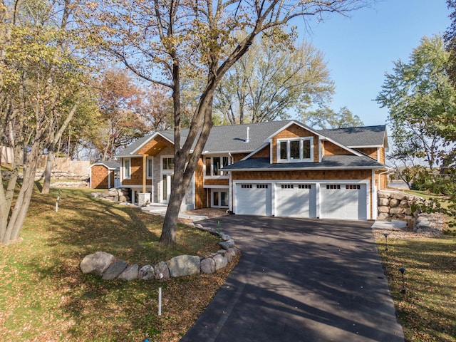 5517 Dickson Rd, Minnetonka, MN 55345 - view of front of home with asphalt driveway, a shingled roof, french doors, a front lawn, and a garage