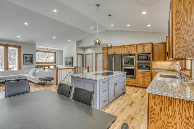 5517 Dickson Rd, Minnetonka, MN 55345 - kitchen with a sink, appliances with stainless steel finishes, open floor plan, a kitchen island, and light stone counters