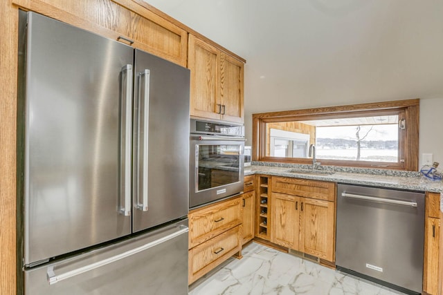 5517 Dickson Rd, Minnetonka, MN 55345 - kitchen with stainless steel appliances, a sink, light marble finish floors, and light stone countertops