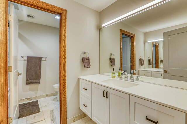 5517 Dickson Rd, Minnetonka, MN 55345 - bathroom with baseboards, vanity, marble finish floors, and toilet