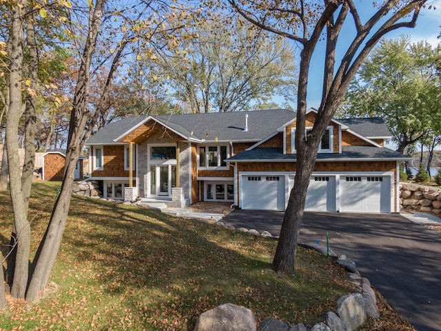 5517 Dickson Rd, Minnetonka, MN 55345 - view of front of house with asphalt driveway, a front yard, and a shingled roof