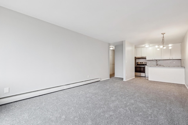 unfurnished living room with light colored carpet, a notable chandelier, and a baseboard heating unit