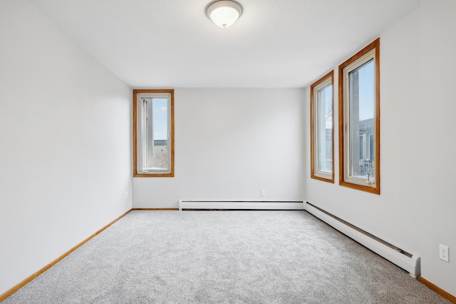 carpeted spare room featuring a baseboard radiator