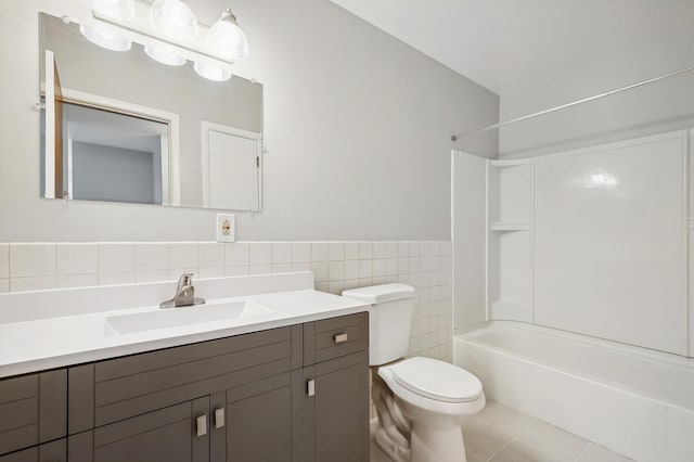 full bathroom featuring tile patterned flooring, toilet, shower / tub combination, vanity, and tile walls