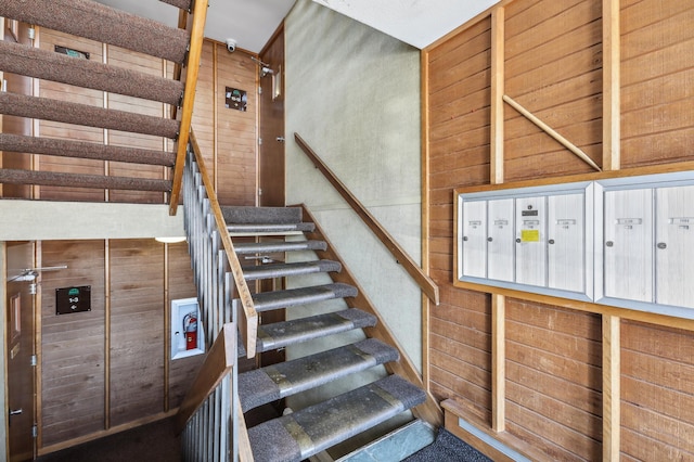 stairs featuring mail boxes and wood walls