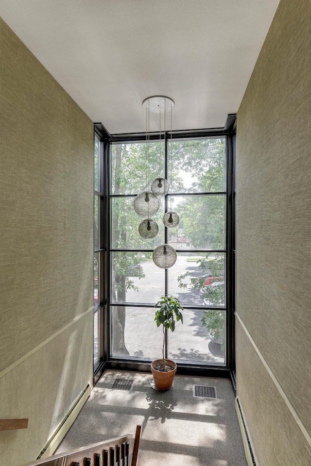 unfurnished sunroom featuring a baseboard heating unit