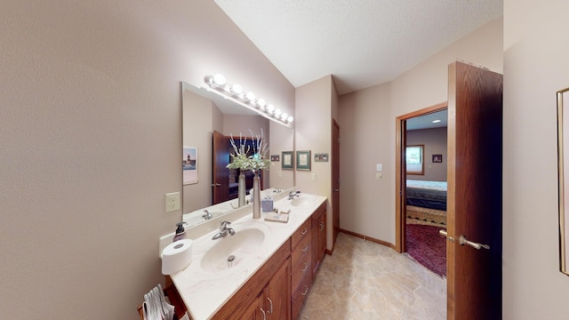 bathroom featuring vanity, lofted ceiling, and a textured ceiling