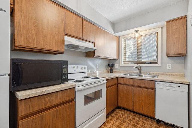 kitchen featuring light countertops, white appliances, a sink, and under cabinet range hood