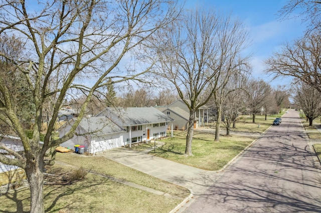 view of front facade featuring a garage, driveway, a front lawn, and covered porch
