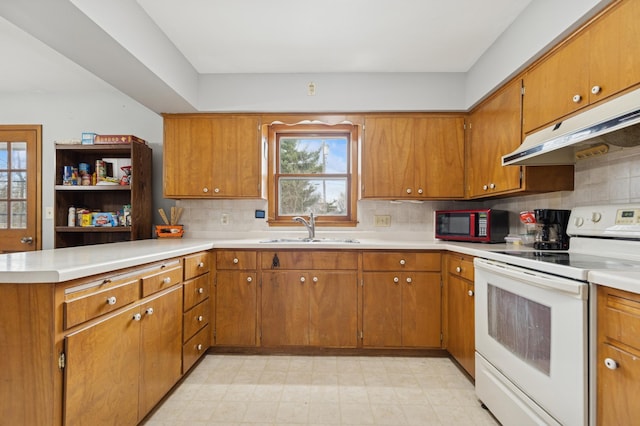 kitchen featuring white electric stove, a healthy amount of sunlight, under cabinet range hood, and a sink