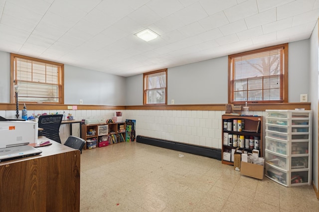 office featuring a wealth of natural light, a wainscoted wall, and tile patterned floors