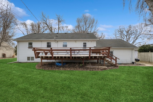 back of property with a wooden deck, fence, a yard, and stairway