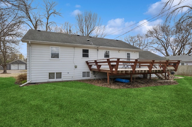 back of house featuring a lawn, a deck, and a shingled roof