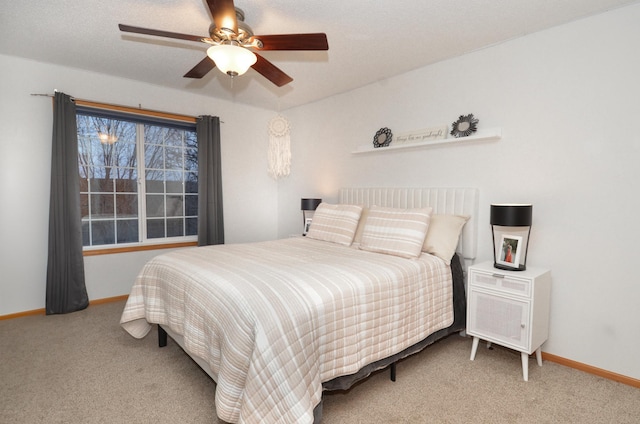 carpeted bedroom featuring a textured ceiling and ceiling fan