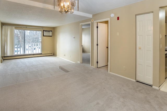 carpeted spare room with a chandelier, a textured ceiling, a baseboard radiator, and a wall unit AC