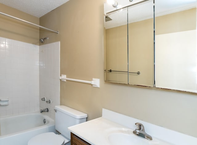 full bathroom with vanity, toilet, a textured ceiling, and tiled shower / bath combo