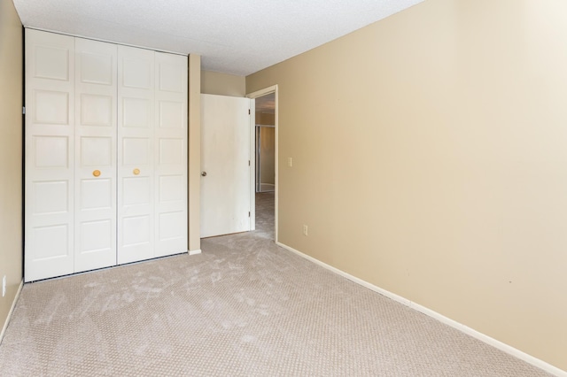 unfurnished bedroom featuring a closet and light colored carpet