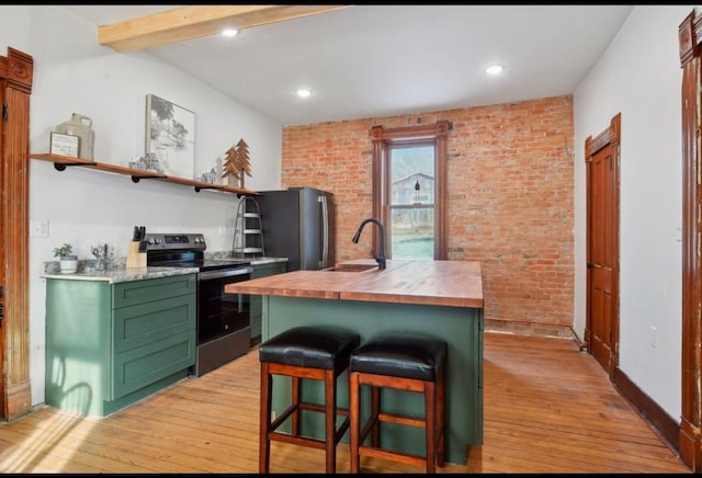 kitchen with light hardwood / wood-style flooring, stainless steel appliances, brick wall, and sink