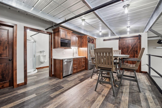 9200 Nike Road 31 & 47, Minnetrista, MN 55359 - kitchen with stainless steel appliances, a barn door, light countertops, dark wood-type flooring, and baseboards