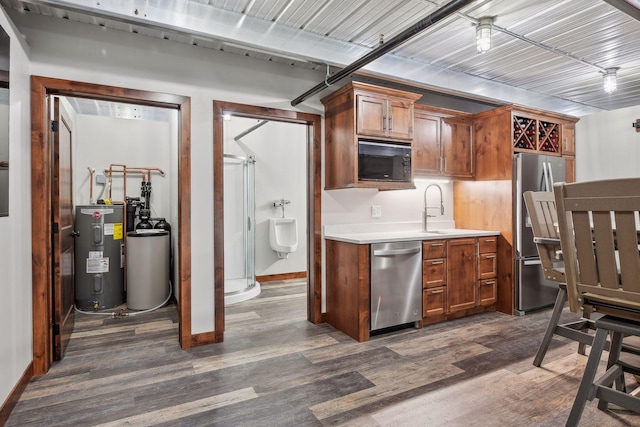 kitchen with sink, dark hardwood / wood-style flooring, stainless steel appliances, and water heater