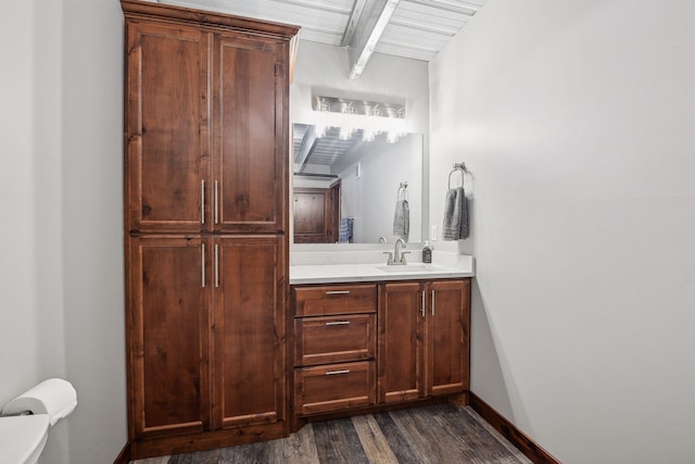 bathroom with beam ceiling, wooden ceiling, vanity, and wood-type flooring