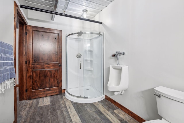 bathroom featuring toilet, an enclosed shower, and wood-type flooring