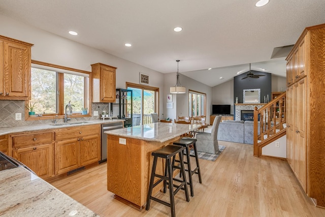 kitchen with tasteful backsplash, a breakfast bar, vaulted ceiling, dishwasher, and a kitchen island