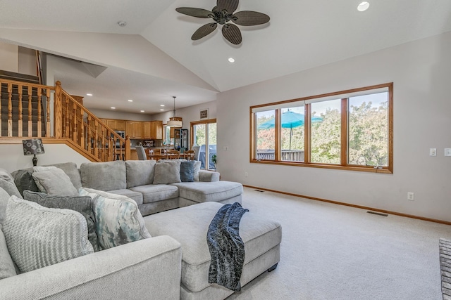 carpeted living room featuring ceiling fan and lofted ceiling