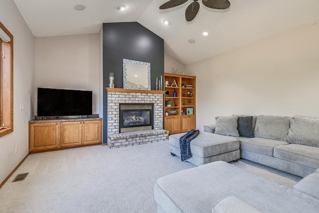 carpeted living room with ceiling fan, lofted ceiling, and a brick fireplace