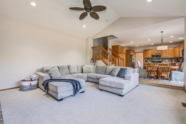 living room featuring ceiling fan, light carpet, and vaulted ceiling