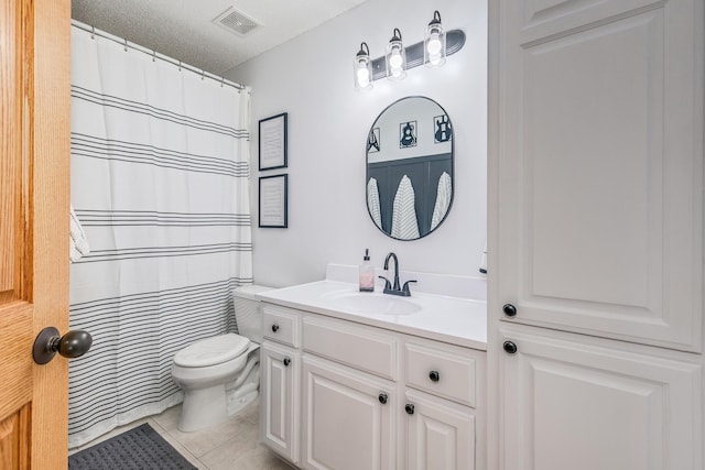 bathroom with tile patterned floors, vanity, toilet, and a textured ceiling