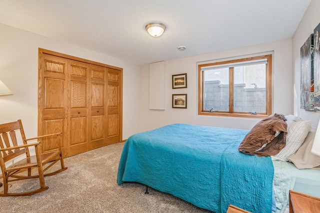 carpeted bedroom featuring a textured ceiling and a closet